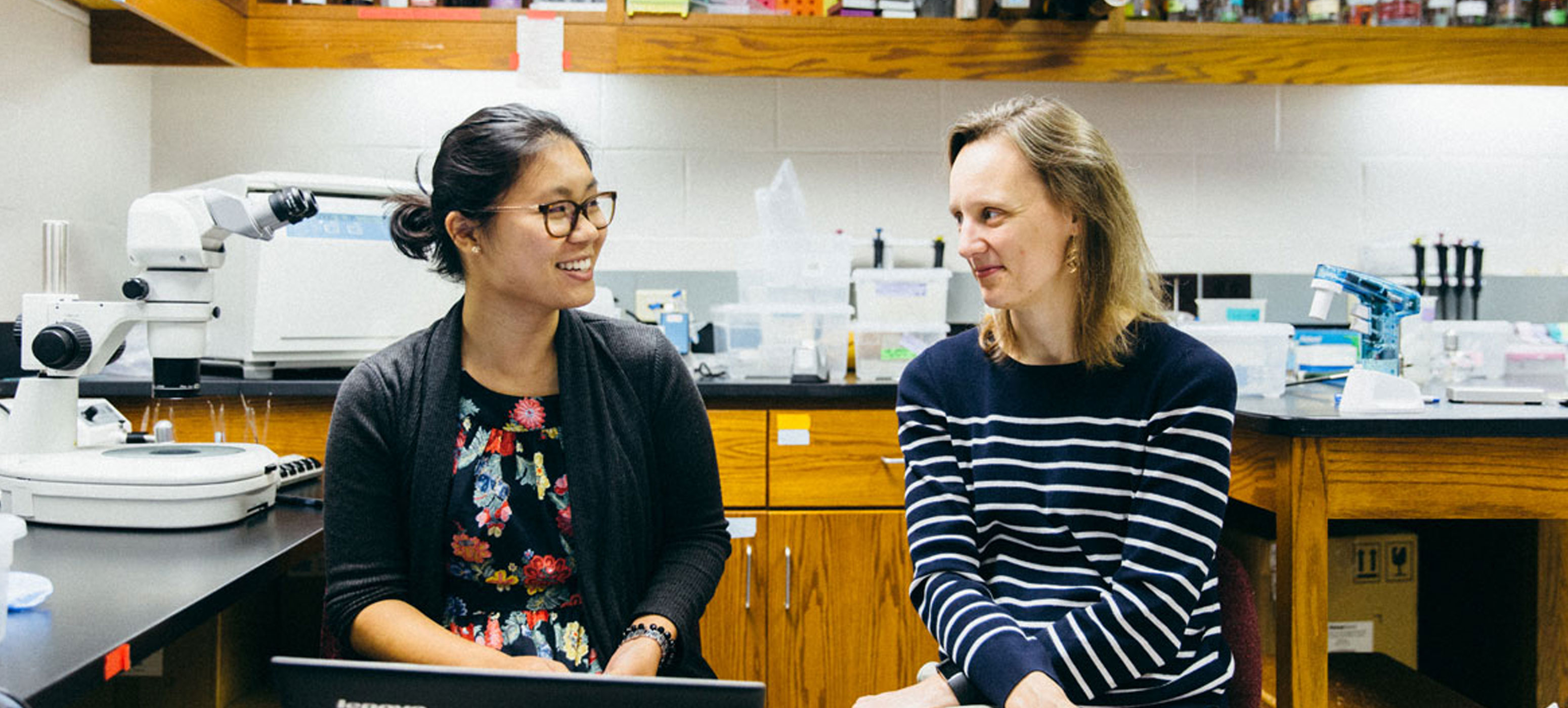 Zoe Yeoh 18 and Biology Professor Jennifer Powell sitting in a lab