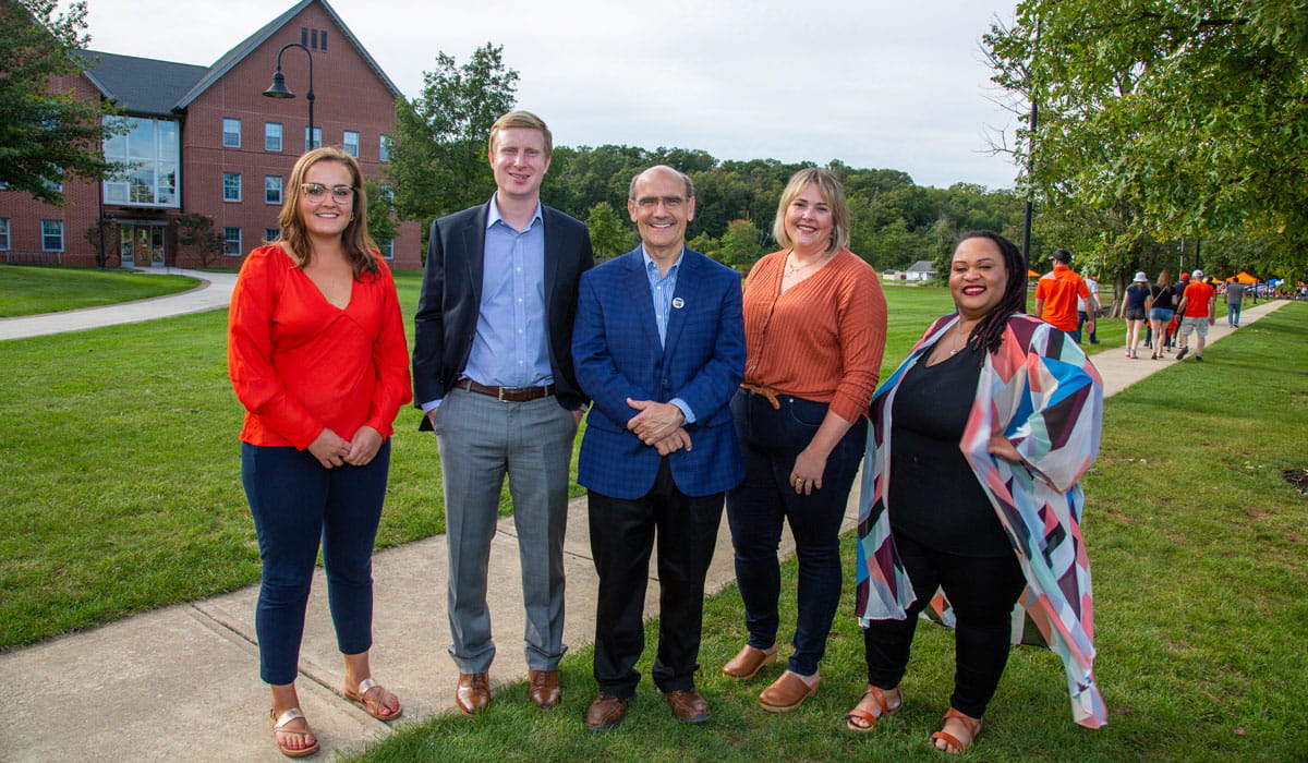 Bob Iuliano posing with students and employees at homecoming weekend 2021